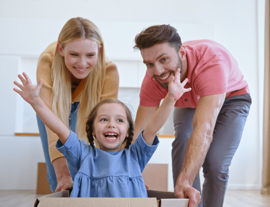 kid in a box being pushed by her parents